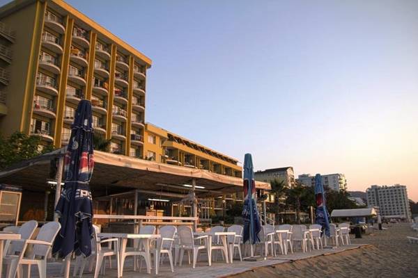Außenbereich des Sentido Golden Star Hotels mit Tischen und Stühlen auf dem Sandstrand