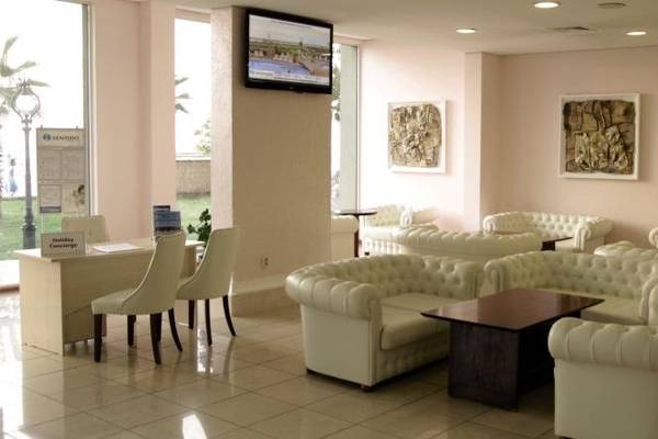 Lobby des Sentido Golden Star Hotels mit weißen Möbeln und Gemälden an der Wand.