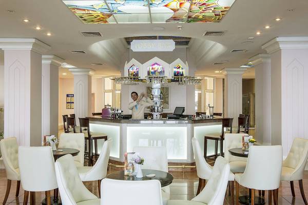 Lobby-Bar im Sentido Golden Star Hotel mit Barkeeper und weißen Möbeln.