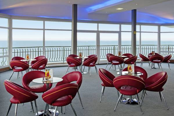 Innenbereich des Sentido Golden Star Hotels mit Blick auf das Meer und rote Stühle.
