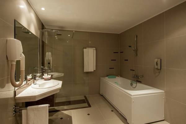 Badezimmer im Sentido Golden Star Hotel mit Badewanne, Dusche und Waschbecken.