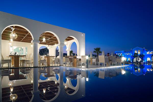 Außenbereich des Anemos Luxury Grand Resort bei Nacht mit blauer Beleuchtung und Pool