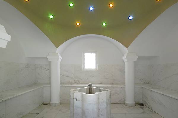 Saunabereich im Anemos Luxury Grand Resort mit weißen Marmorwänden und einer zentralen Badewanne.