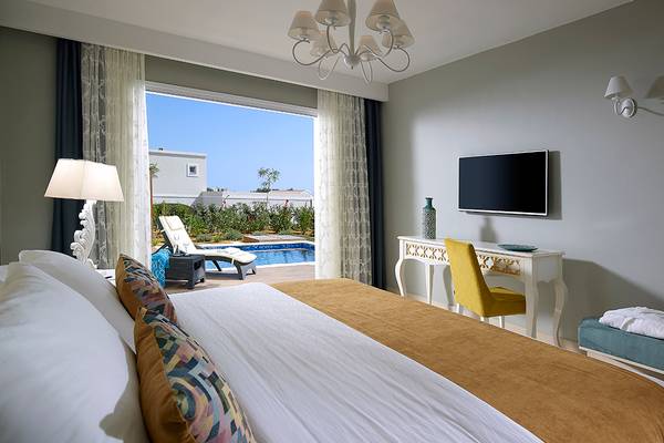 Schlafzimmer im Anemos Luxury Grand Resort mit Aussicht auf den Pool.