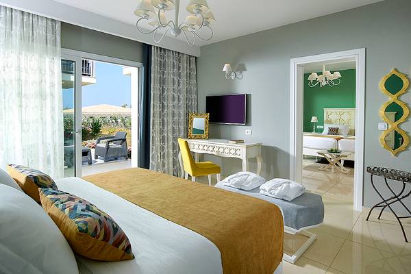 Hotelzimmer im Anemos Luxury Grand Resort mit Blick auf die Terrasse und Möbeln.
