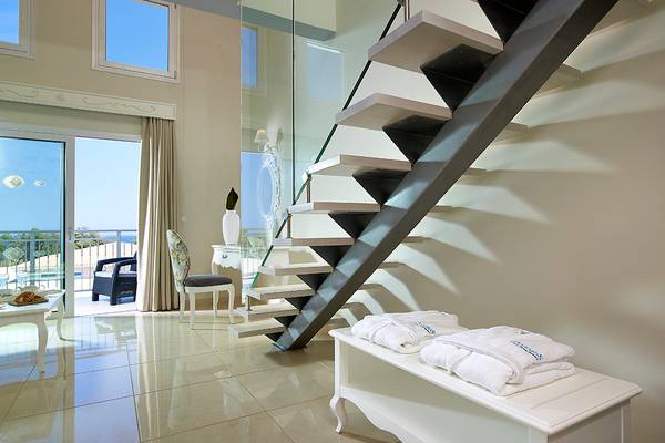 Innenbereich des Anemos Luxury Grand Resort mit Treppen, Balkon und Blick auf das Meer