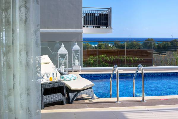 Ansicht des Balkons des Anemos Luxury Grand Resort mit Swimmingpool und Meerblick.