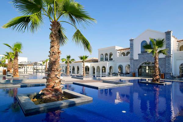 Außenbereich des Anemos Luxury Grand Resort mit Swimmingpool und Palmen
