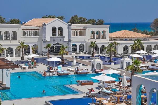 Außenbereich des Anemos Luxury Grand Resort mit Pools und Sonnenliegen