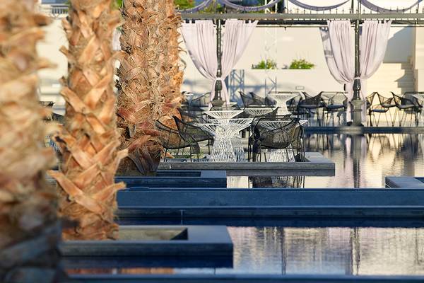 Sitzecke mit Tischen und Stühlen im Freien im Anemos Luxury Grand Resort.