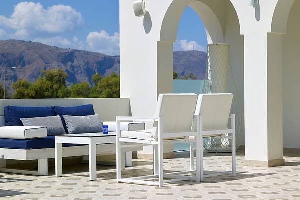 Terrasse des Anemos Luxury Grand Resort mit Blick auf die Berge und modernen Möbeln.