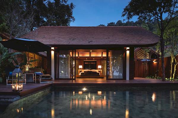 Nachtansicht des Tubkaak Krabi Boutique Resorts mit beleuchtetem Zimmer und Pool.