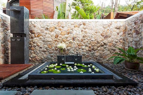 Außenbereich des Tubkaak Krabi Boutique Resorts mit Wasserbecken und Pflanzen