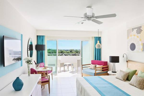 Innenansicht eines Zimmers im Playa Vista Azul Varadero Hotel mit Blick auf eine Terrasse.