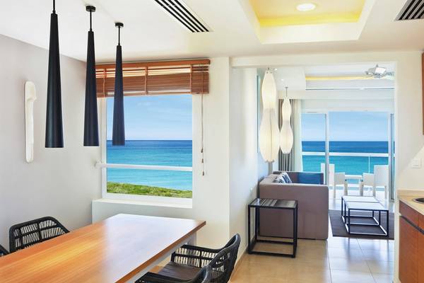 Hotelzimmer mit Blick auf das Meer und den Strand aus einem großen Fenster.