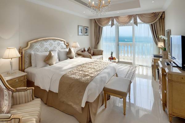 Luxuriöses Hotelschlafzimmer mit Meerblick, elegantes Bett, Möbel und Balkon.