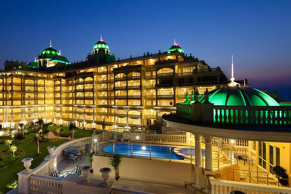 Kempinski Hotel Residenzen Palm Jumeirah bei Nacht mit beleuchteten Geb äuden und Pool.