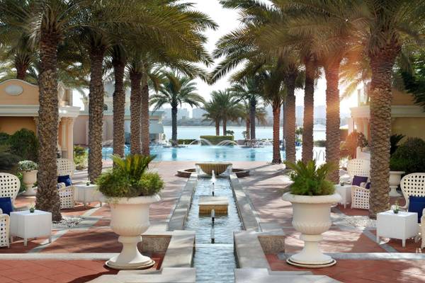 Außenbereich des Kempinski Hotel Residences Palm Jumeirah mit Swimmingpool und weißen Möbeln.