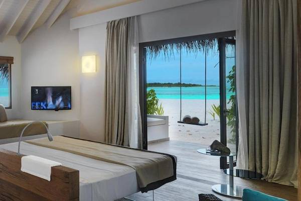 Innenansicht der Suite im Cocoon Maldives Hotel mit Blick auf das Meer.