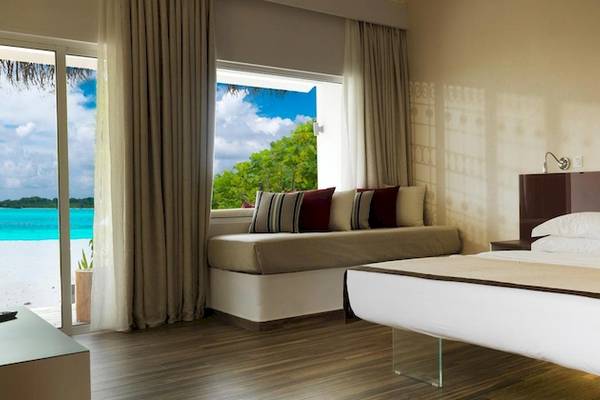 Innenansicht eines Cocoon Maldives Hotelzimmers mit Meerblick und moderner Einrichtung.