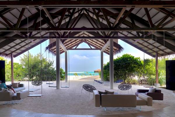 Loungebereich im Cocoon Maldives Hotel mit Blick auf den Strand und das Meer.