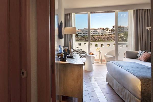 Innenansicht eines Hotelzimmers im Fuerteventura Princess mit Blick auf die Außenterrasse und die Landschaft.
