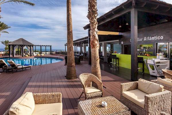 Außenbereich des Occidental Jandia Royal Level Hotels mit Bar Atlántico, Loungemöbeln und Swimmingpool.