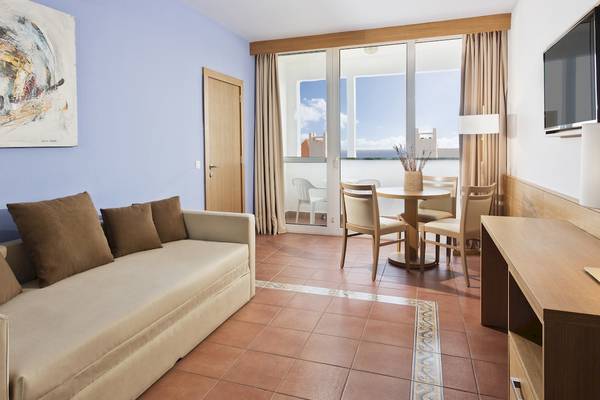 Wohnbereich im Fuerteventura Princess Hotel mit Sofa, Esstisch und Meerblick.