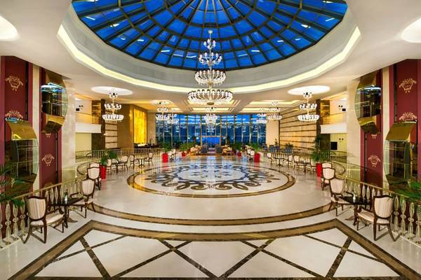 Lobby des Vogue Hotel Supreme Bodrum mit blauer Glaskuppel und Kronleuchtern.