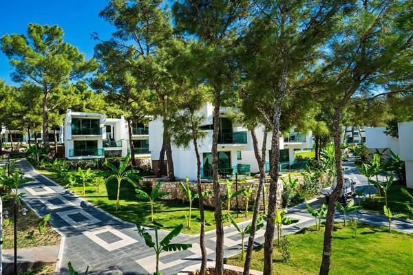 Aerial view of the Vogue Hotel Supreme Bodrum surrounded by trees and green grass.