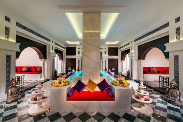 Lobby-Lounge im Vogue Hotel Supreme Bodrum mit Früchtebuffet, Couch und Buddha-Statuen.