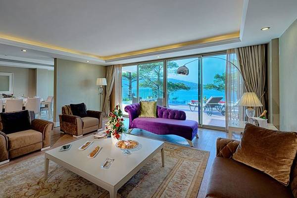 Wohnzimmer des Vogue Hotel Supreme Bodrum mit Blick auf das Meer und modernen Möbeln.
