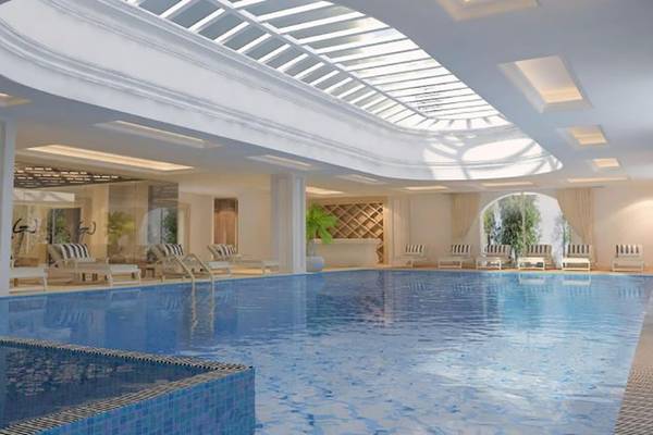 Innenpool des Vogue Hotel Supreme Bodrum mit Loungeliegen und Pflanzen.