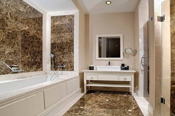 Badezimmer im Vogue Hotel Supreme Bodrum mit Badewanne, Waschbecken und Spiegel.