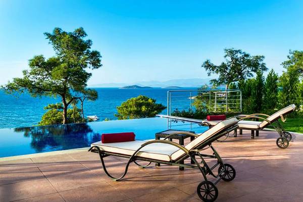 Sonnenliegen am Pool des Vogue Hotel Supreme Bodrum mit Blick auf das Meer