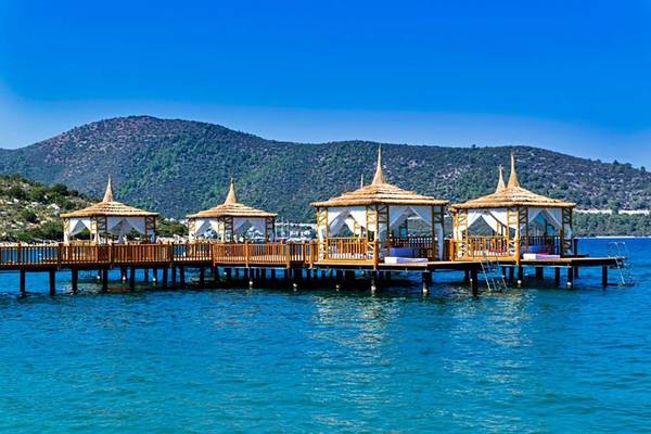 Pool-Lounges des Vogue Hotel Supreme Bodrum mit Blick auf das Meer und Berge.