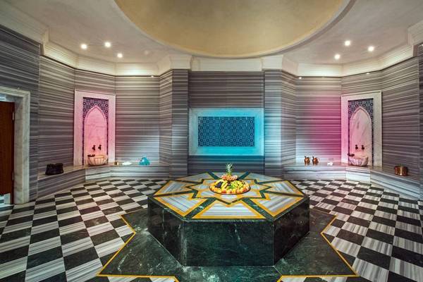 Innenansicht der Sauna im Vogue Hotel Supreme Bodrum mit grünem Marmortisch und Obstkorb.