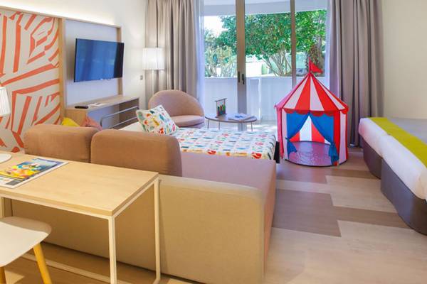 Innenansicht eines Zimmers im Abora Buenaventura Hotel mit einem Sofa, einem Bett und einem Zirkuszelt.
