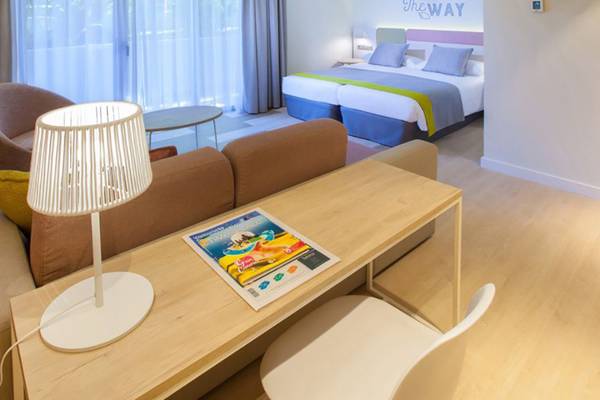 Innenansicht eines Zimmers im Abora Buenaventura by Lopesan Hotels mit Bett, Schreibtisch und Möbeln.
