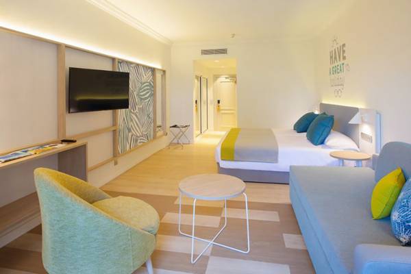 Innenansicht eines Hotelzimmers im Abora Buenaventura mit Bett, Sofa, Fernseher und Schreibtisch