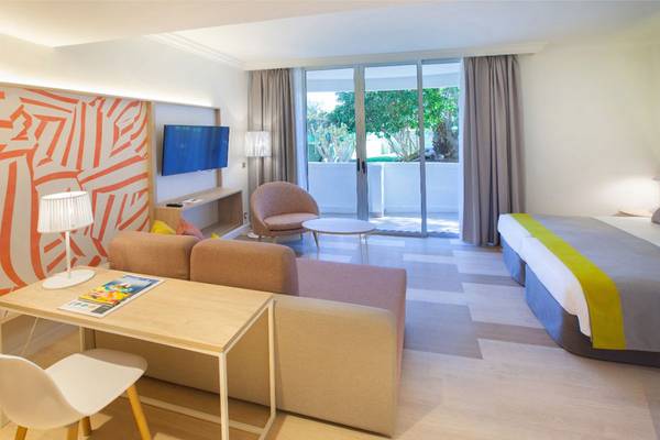 Innenansicht eines Hotelzimmers von Abora Buenaventura mit Schlafbereich, Wohnzimmer und Terrasse.