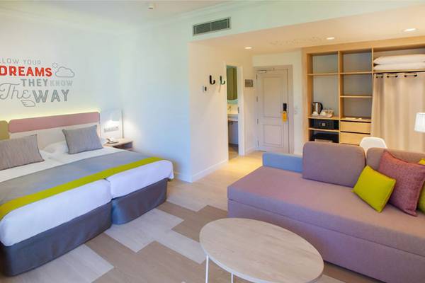 Innenansicht eines Zimmers im Abora Buenaventura Hotel mit Doppelbett, Sofa und Tisch