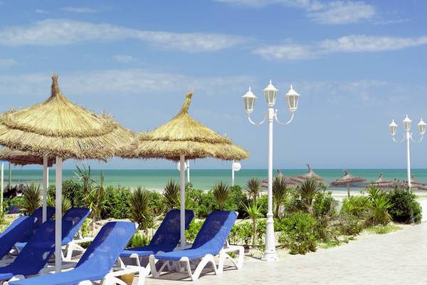 Strand mit Sonnenliegen unter Sonnenhüten im Calimera Yati Beach
