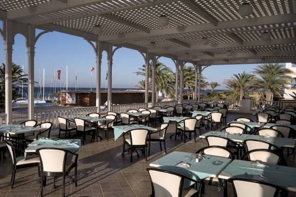 Terrasse des Calimera Yati Beach Hotels mit Blick auf das Meer und Palmen