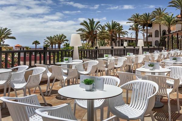 Terrasse des Occidental Jandia Mar Hotels mit vielen weißen Stühlen und Tischen im Freien.
