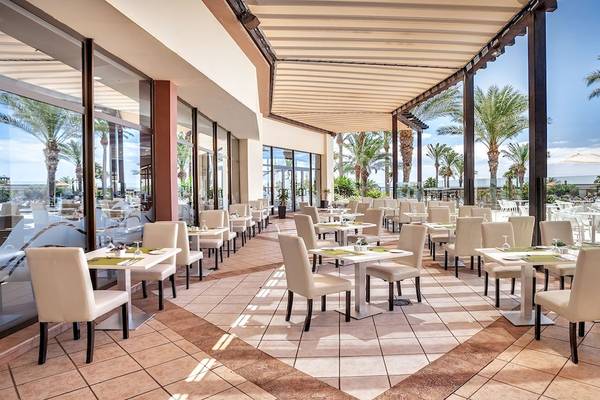 Innenansicht des Restaurants im Occidental Jandia Mar Hotel mit vielen Tischen und Stühlen unter einem Markisendach.