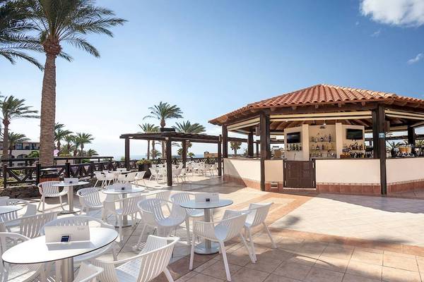 Außenbereich des Occidental Jandia Mar Hotels mit Bar und Tischen im Freien.
