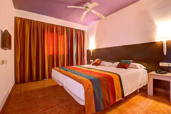 Hotelzimmer im SBH Monica Beach Resort mit Doppelbett, Deckenventilator und Nachttisch.