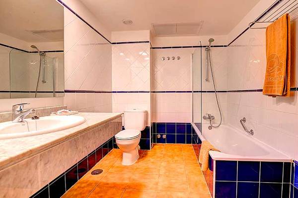 Badezimmer im SBH Monica Beach Resort mit Badewanne, Toilette und Waschbecken.