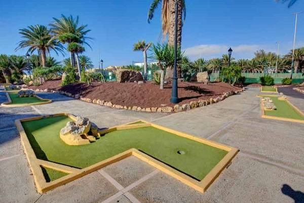 Minigolf-Kurs im SBH Monica Beach Resort mit Palmen und Grünflächen.